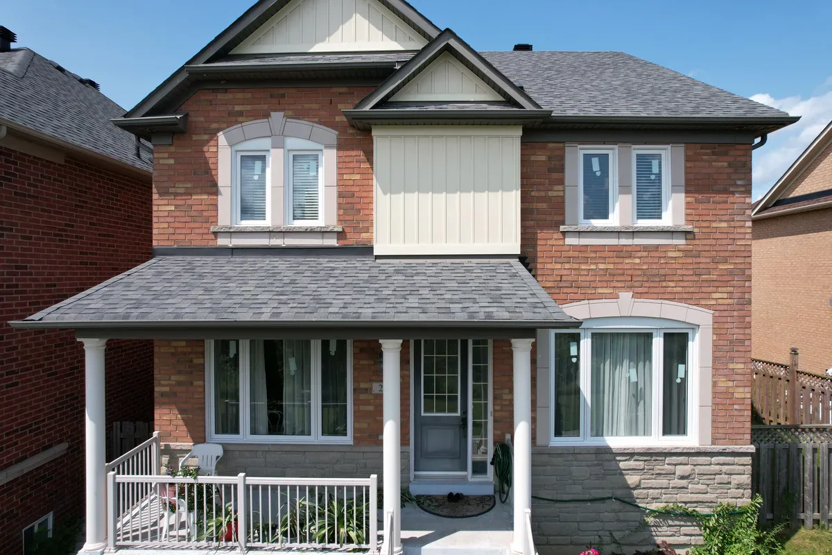 Aerial view of a Toronto brick home with newly installed windows and a landscaped front yard